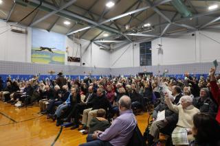 a photo of voters raising their cards at 2023 special town meeting